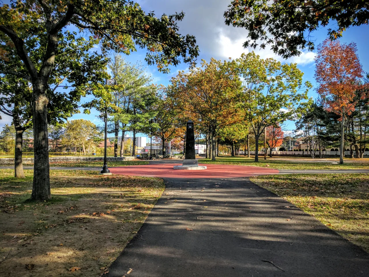 An obelisk stands among autumn trees at World War II Veterans Memorial State Park in Woonsocket.